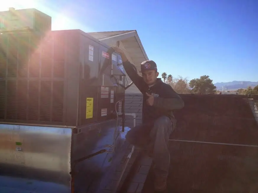 HVAC technician performing Heat Pump Repair on a rooftop unit in Bowie
